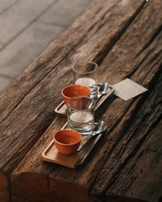 Two espresso cups served on the textured wooden counter at DOT.